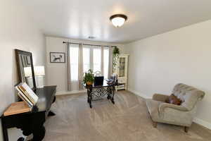 Office space with light colored carpet and baseboards