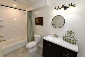 Bathroom with vanity, shower / bath combination with curtain, recessed lighting, and light tile patterned floors