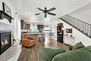 Living room featuring a tiled fireplace, dark wood-style floors, ceiling fan, and recessed lighting