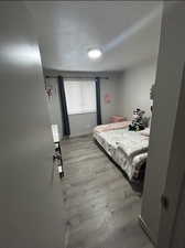 Bedroom with light wood-type flooring and baseboards