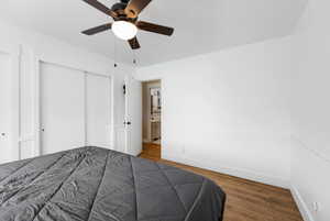 Bedroom with wood finished floors, a closet, and ceiling fan