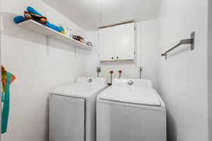 Laundry room featuring washing machine and clothes dryer and cabinet space