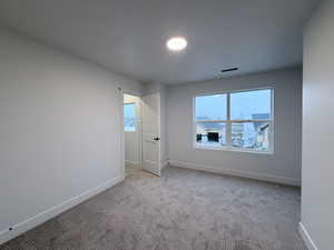 Carpeted empty room with baseboards