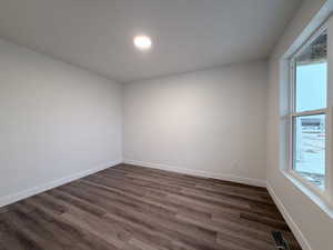 Spare room with dark wood finished floors and baseboards