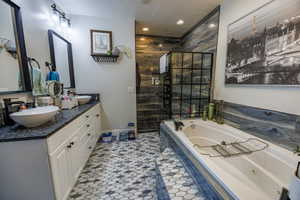 Full bathroom with double vanity, tiled shower, a jetted tub, recessed lighting, and light tile patterned flooring