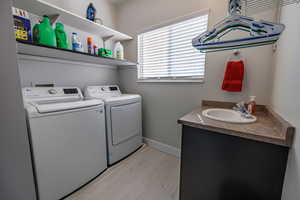 Laundry area featuring washer and dryer and light wood-style flooring