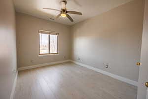Unfurnished room with ceiling fan and light wood finished floors