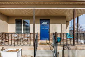 Entrance to property featuring stucco siding and a porch