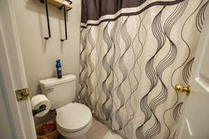 Full bath with curtained shower and toilet