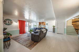 Living area featuring light wood finished floors and a textured ceiling