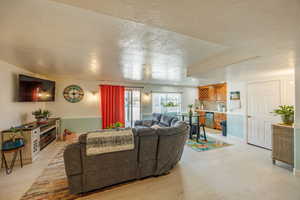 Living room featuring light wood-style floors, a textured ceiling, wet bar, and recessed lighting