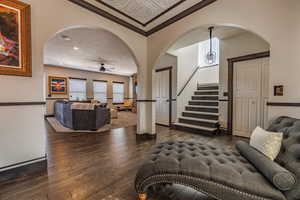 Living area featuring arched walkways, dark wood-style floors, recessed lighting, an ornate ceiling, and a ceiling fan