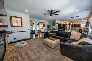 Living area with arched walkways, recessed lighting, and a ceiling fan