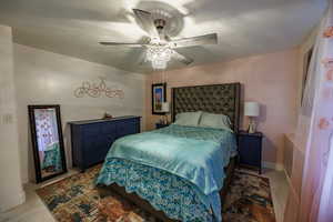 Bedroom with a ceiling fan and baseboards