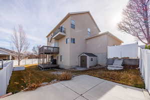 Back of property with a patio area, a fenced backyard, a storage unit, and a wooden deck