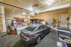 Garage featuring freestanding refrigerator and a garage door opener