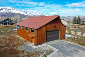 Detached garage featuring a mountain view and gravel driveway