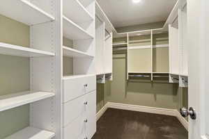 Walk in closet featuring dark colored carpet