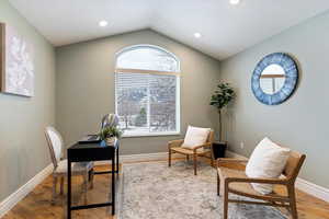 Office area with light wood-style floors and recessed lighting