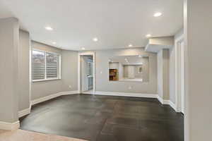 Unfurnished living room featuring baseboards and recessed lighting