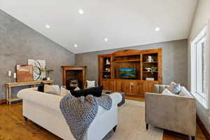Living area featuring vaulted ceiling, light wood-type flooring, and recessed lighting