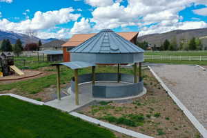 View of yard with a mountain view, a gazebo, a patio area, and a playground