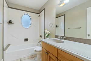 Full bathroom with vanity, light tile patterned floors, and shower / bath combination