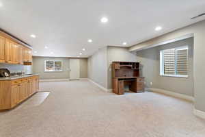 Kitchen featuring light carpet, open floor plan, recessed lighting, and light countertops