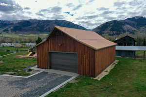 Detached garage with a mountain view and gravel driveway
