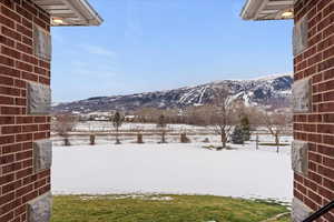 Yard layered in snow with a mountain view