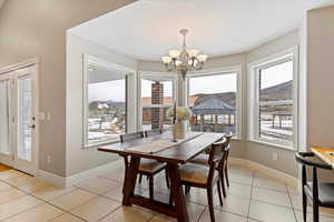 Dining area with plenty of natural light, hanging lights, light tile patterned floors, and a mountain view