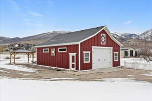 Snow covered garage featuring a mountain view and a detached garage
