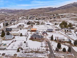 Snowy aerial view with a mountain view and a residential view