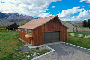Detached garage featuring a mountain view, driveway, and a view of countryside