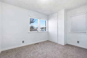 Unfurnished bedroom featuring light carpet and a textured ceiling