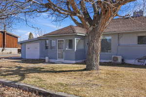 View of front facade featuring brick siding, a front lawn, a garage, and roof with shingles