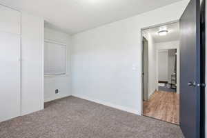 Unfurnished bedroom featuring carpet floors and baseboards