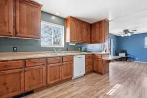 Kitchen with wood finish cabinetry, light countertops, a breakfast bar area, and a peninsula