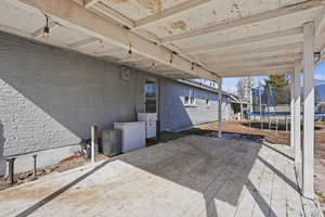 Wooden deck featuring a trampoline and a patio area