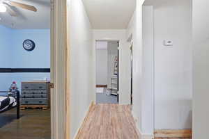 Corridor featuring light wood finished floors and baseboards