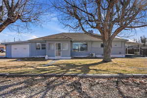 View of front of house with brick siding, an attached garage, a front yard, a chimney, and concrete driveway
