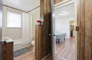 Bathroom featuring light wood-type flooring, shower / bath combo, and vanity