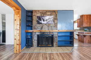 Detailed view of wood finished floors, a fireplace, and white dishwasher