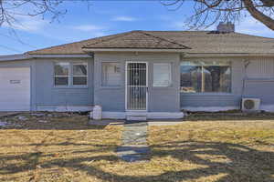 View of front of home featuring brick siding, a chimney, a front yard, and a shingled roof