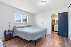 Bedroom featuring wood finished floors and ensuite bath