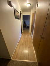 Hallway featuring a textured ceiling and light wood-style flooring