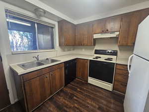 Kitchen featuring electric range oven, freestanding refrigerator, light countertops, black dishwasher, and dark wood-style floors