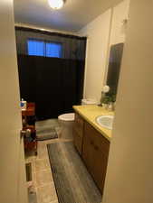 Bathroom featuring vanity, a textured ceiling, light tile patterned floors, and shower / tub combo with curtain