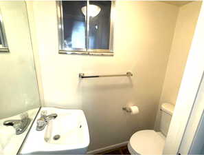 Bathroom featuring toilet and baseboards