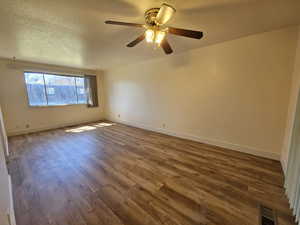Spare room featuring a textured ceiling, wood finished floors, and a ceiling fan